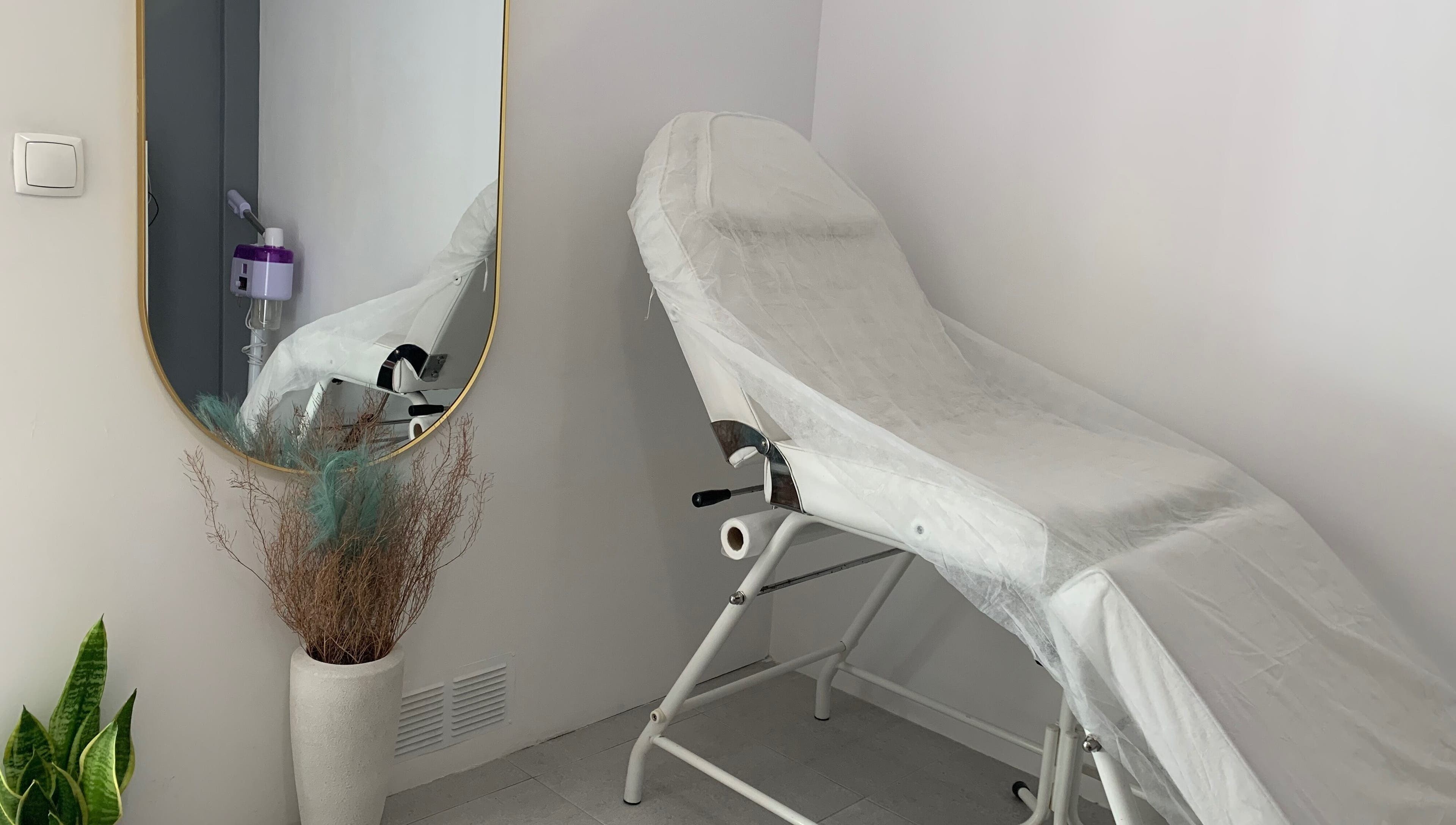 Sala de tratamento elegante em Nei Oliver Esteticista, Almada, Setúbal, PT, com cadeira de estética e espelho.