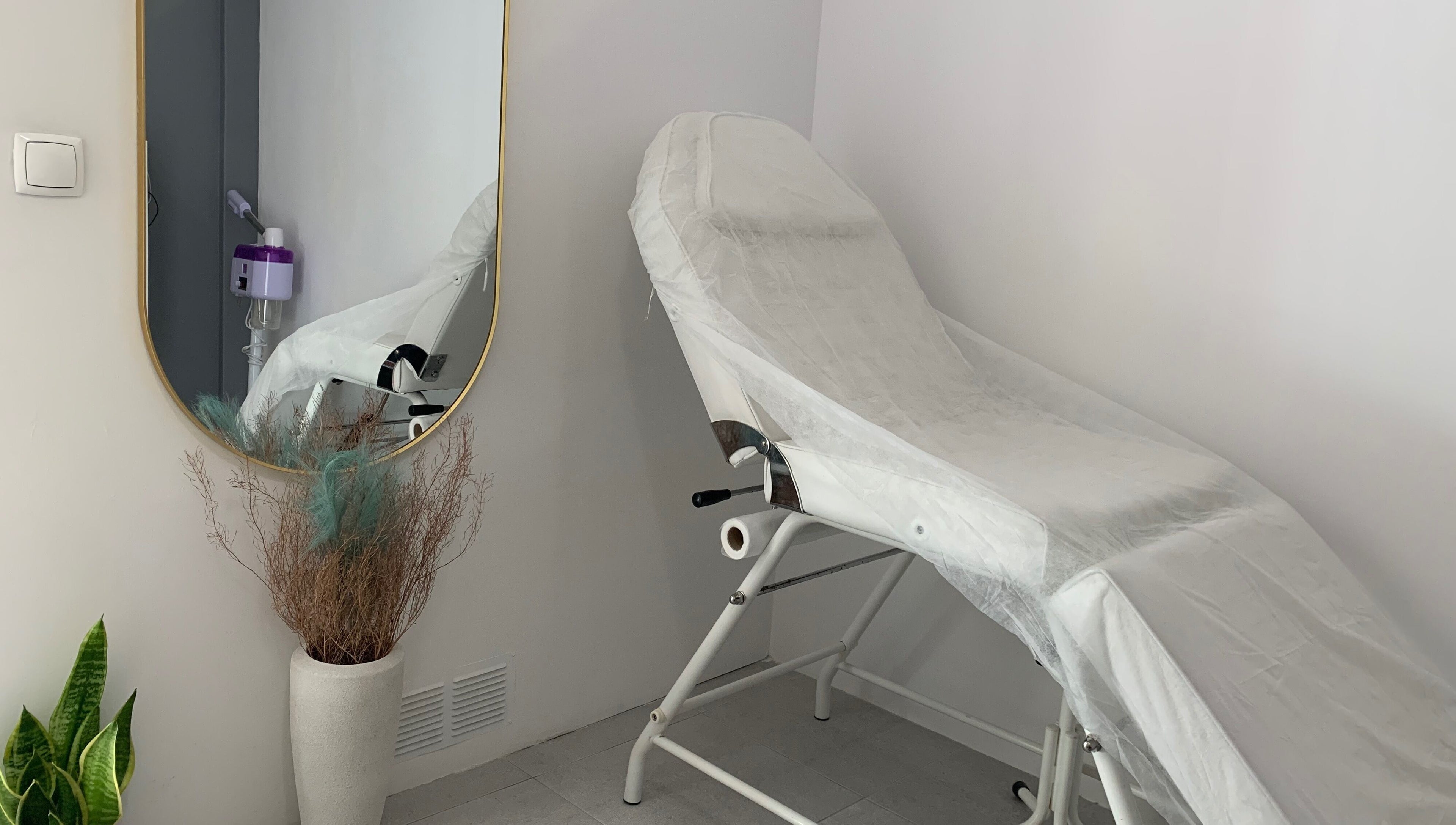 Sala de tratamento elegante em Nei Oliver Esteticista, Almada, Setúbal, PT, com cadeira de estética e espelho.