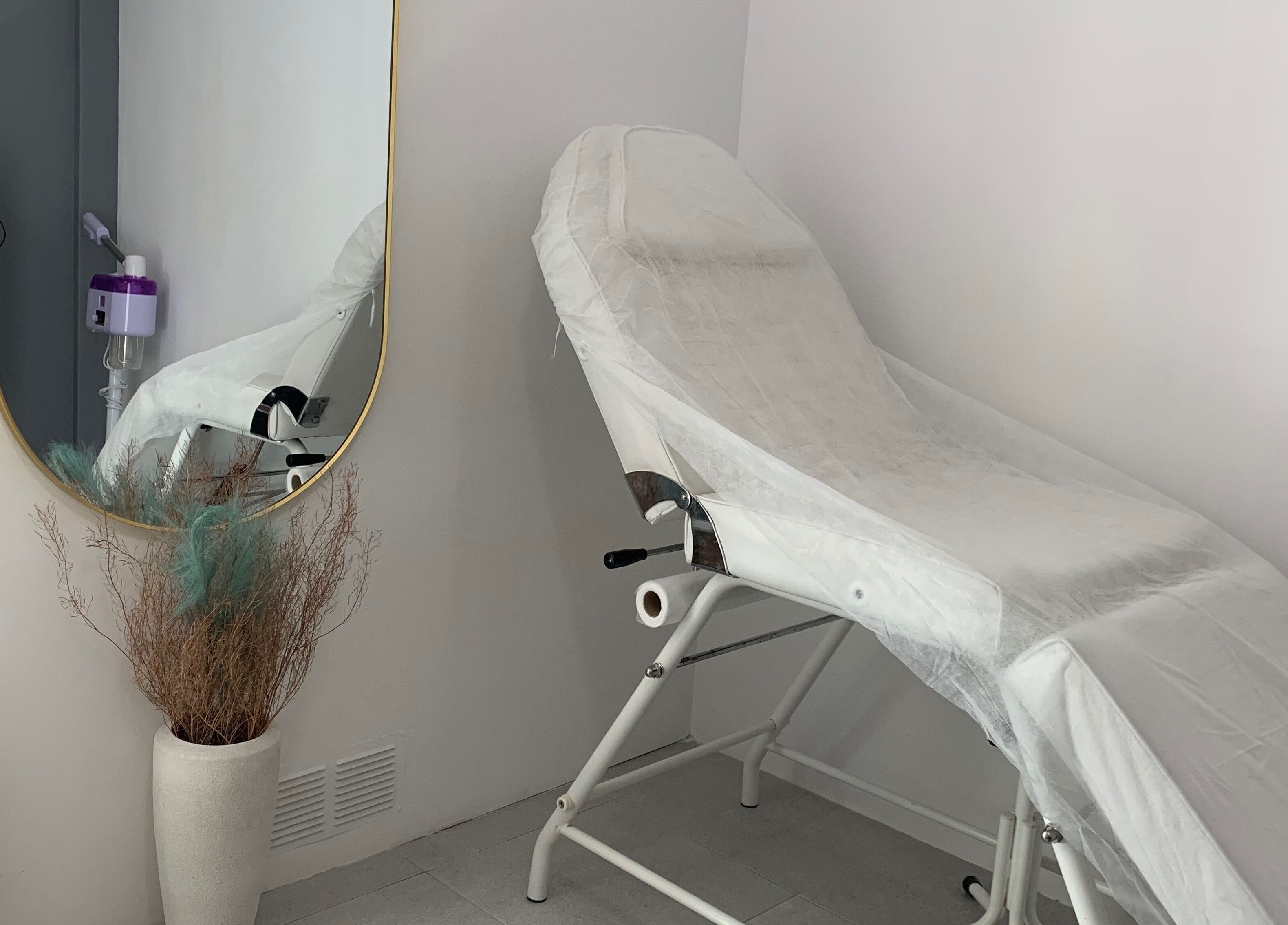 Sala de tratamento elegante em Nei Oliver Esteticista, Almada, Setúbal, PT, com cadeira de estética e espelho.