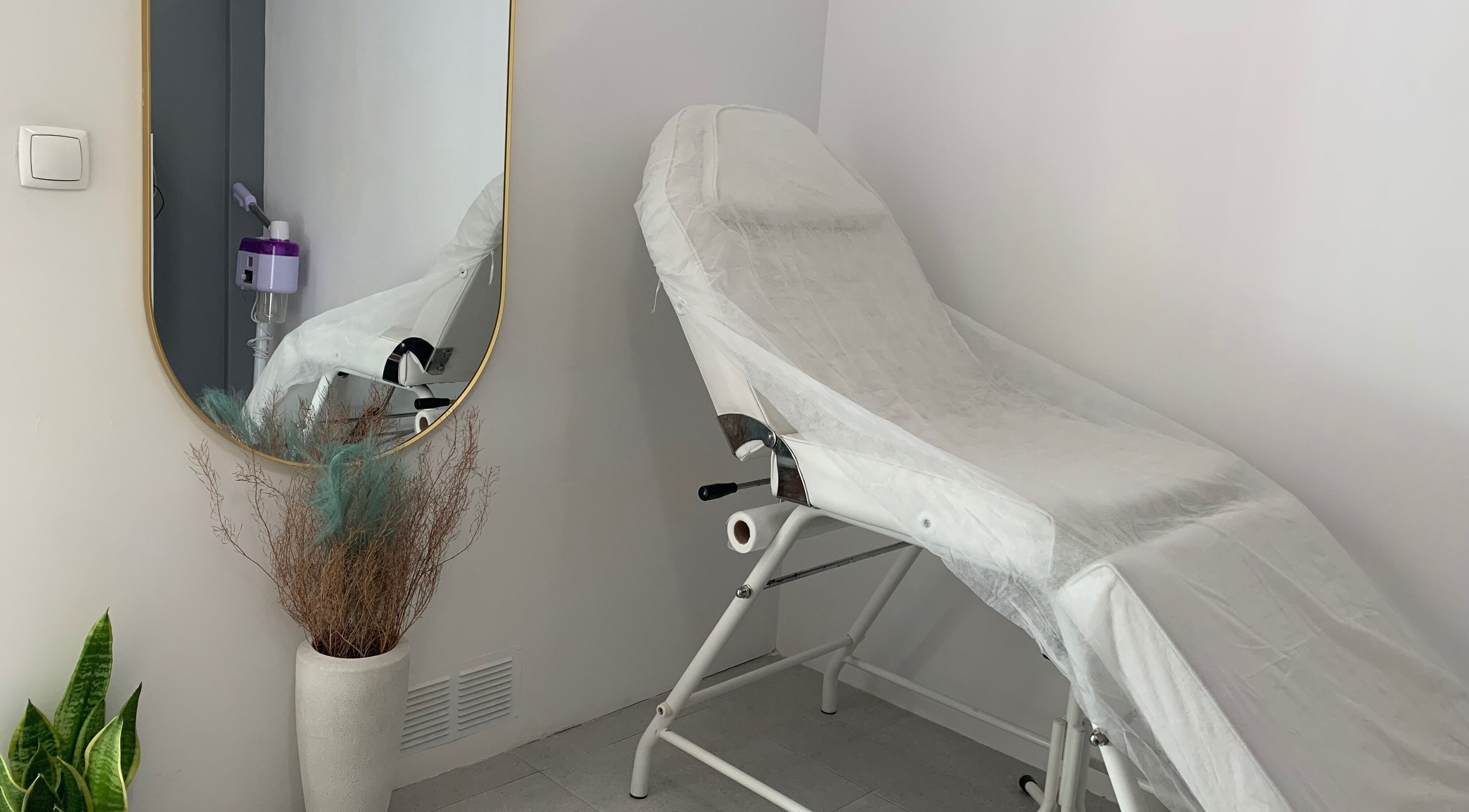 Sala de tratamento elegante em Nei Oliver Esteticista, Almada, Setúbal, PT, com cadeira de estética e espelho.