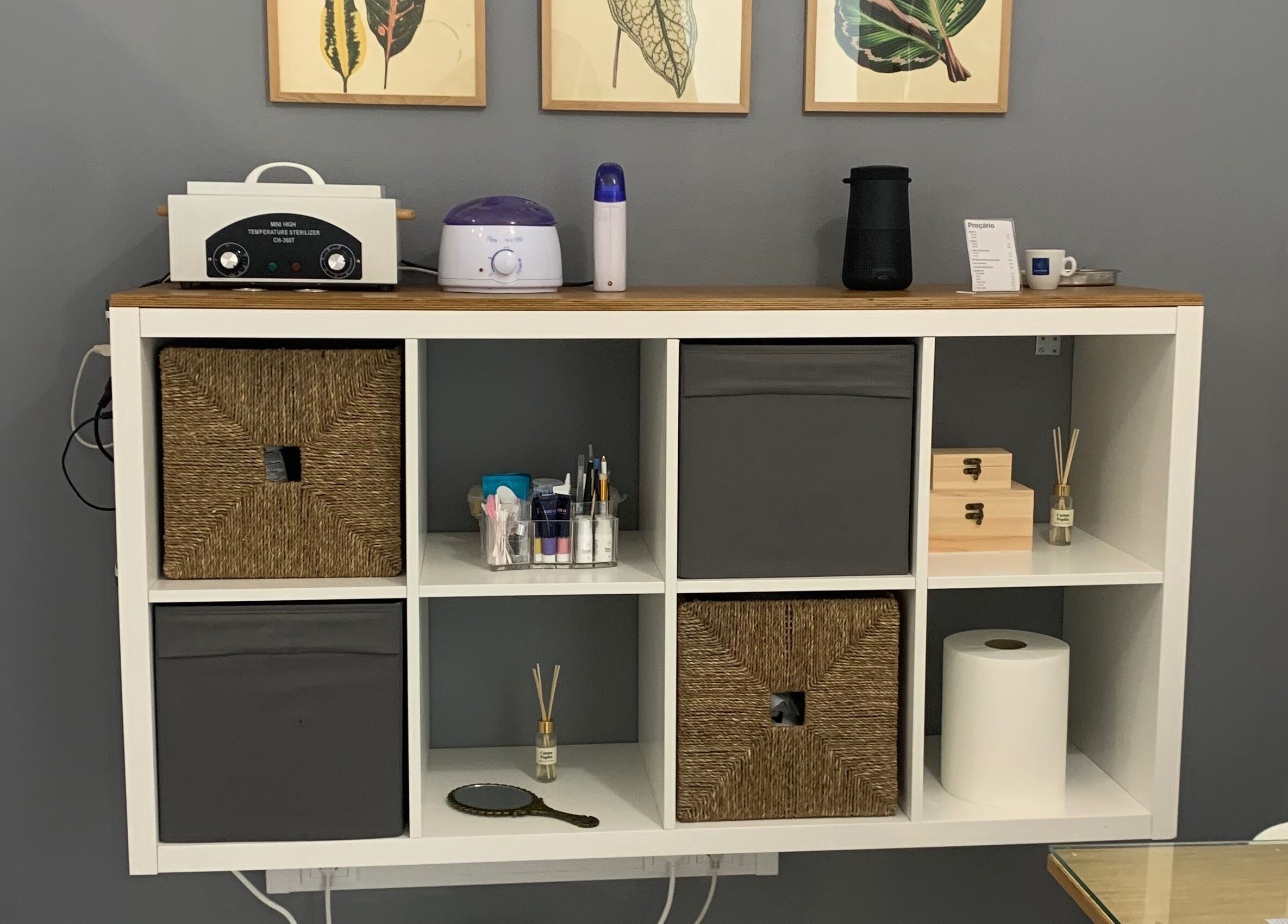 Estante organizada com materiais de beleza na Nei Oliver Esteticista, em Almada, Setúbal, PT.