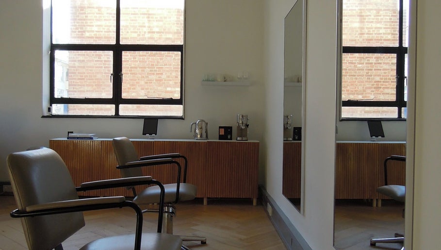 Stylish interior of The Haye Studio in London, England, GB, featuring chic salon chairs and large mirrors.