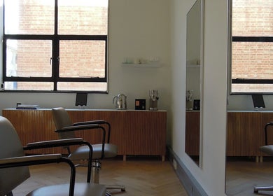Stylish interior of The Haye Studio in London, England, GB, featuring chic salon chairs and large mirrors.