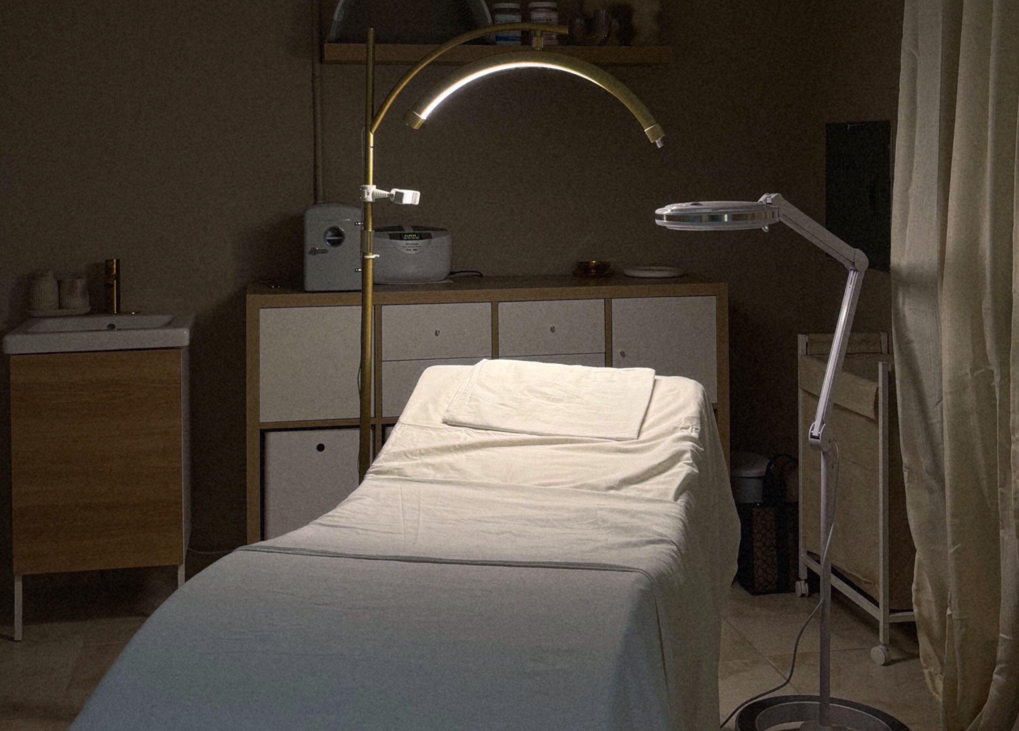 Spacious treatment room at Blizzthetic, San Juan, San Juan, PR, featuring a comfortable bed and elegant lighting.