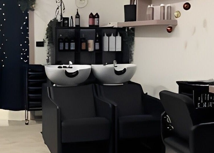 Interno moderno di Studio Capelli F Parrucchieri a Torino, Piemonte, IT con lavabi e sedie eleganti.