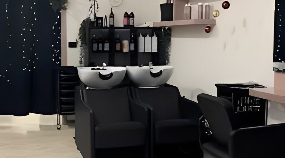 Interno moderno di Studio Capelli F Parrucchieri a Torino, Piemonte, IT con lavabi e sedie eleganti.