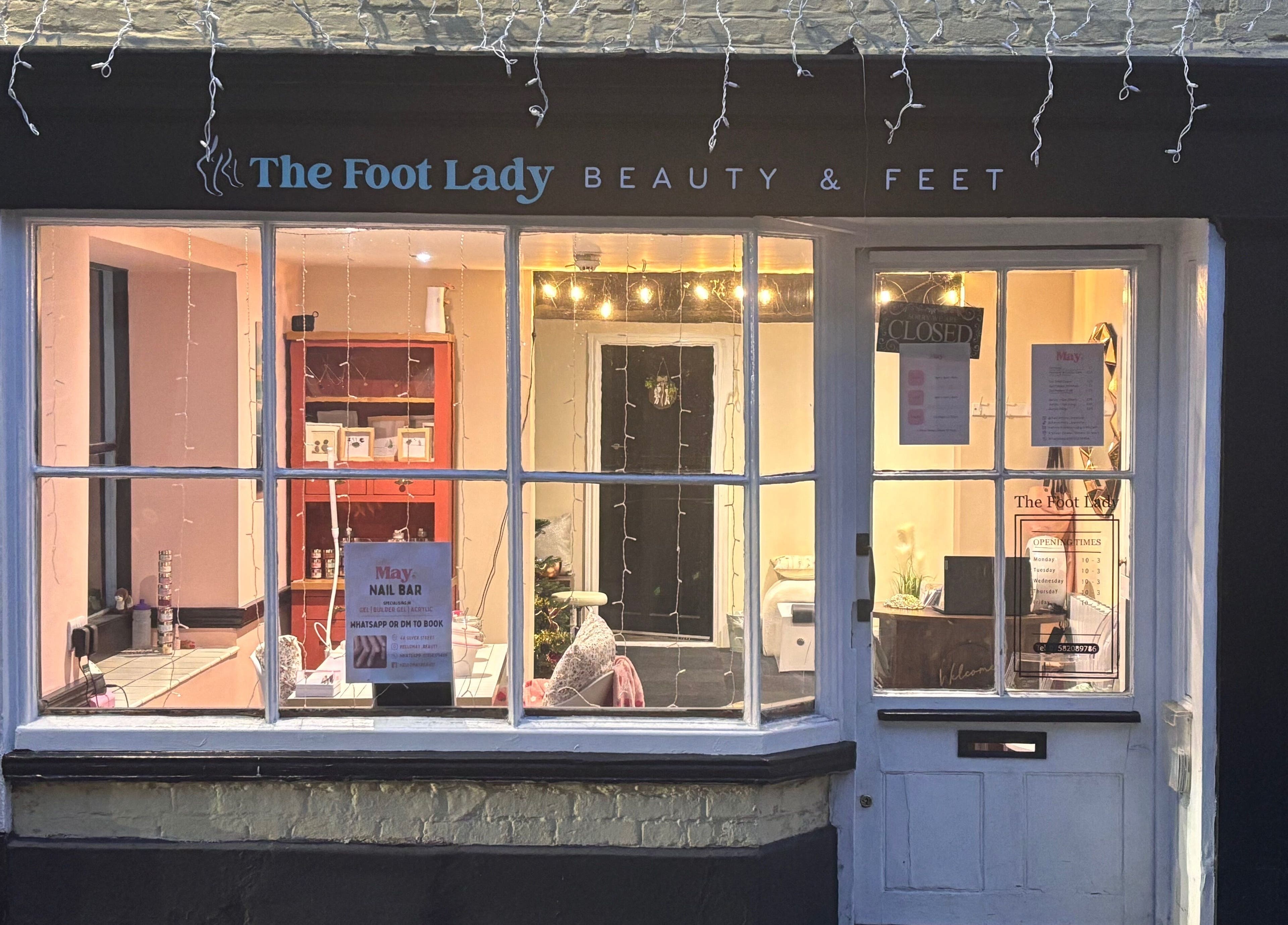 Charming facade of Hello May Beauty in Ottery Saint Mary, England, well-lit window display.