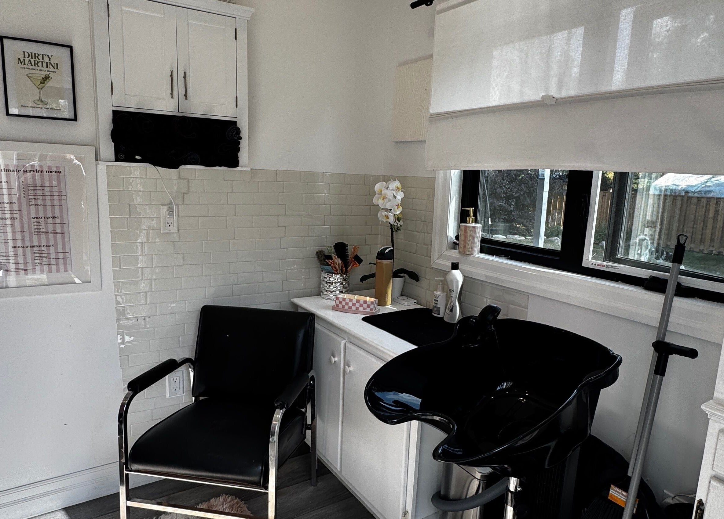 Modern salon interior at Laur’s Glam Files in Brantford, Ontario, CA featuring sleek black chair and wash basin.