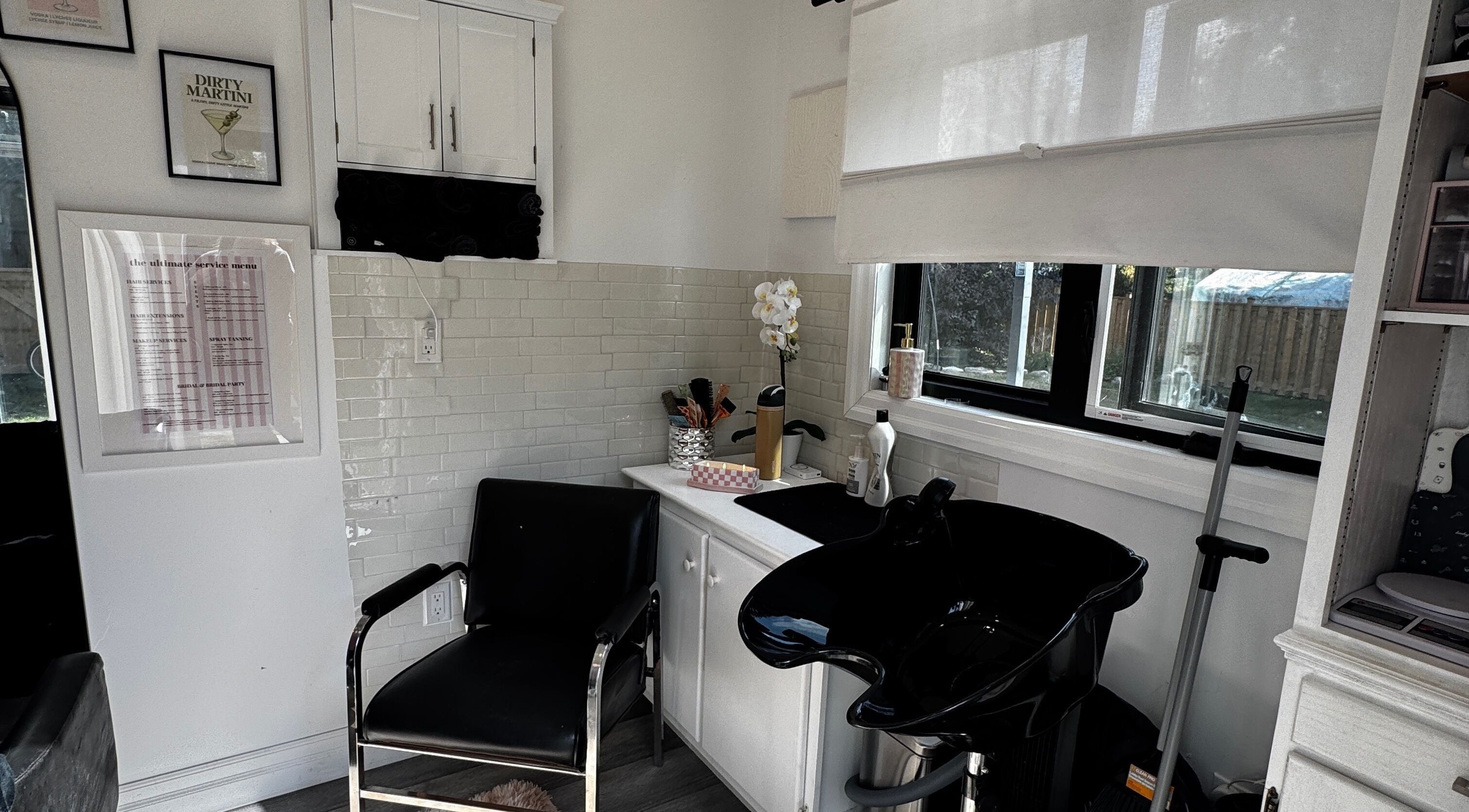 Modern salon interior at Laur’s Glam Files in Brantford, Ontario, CA featuring sleek black chair and wash basin.