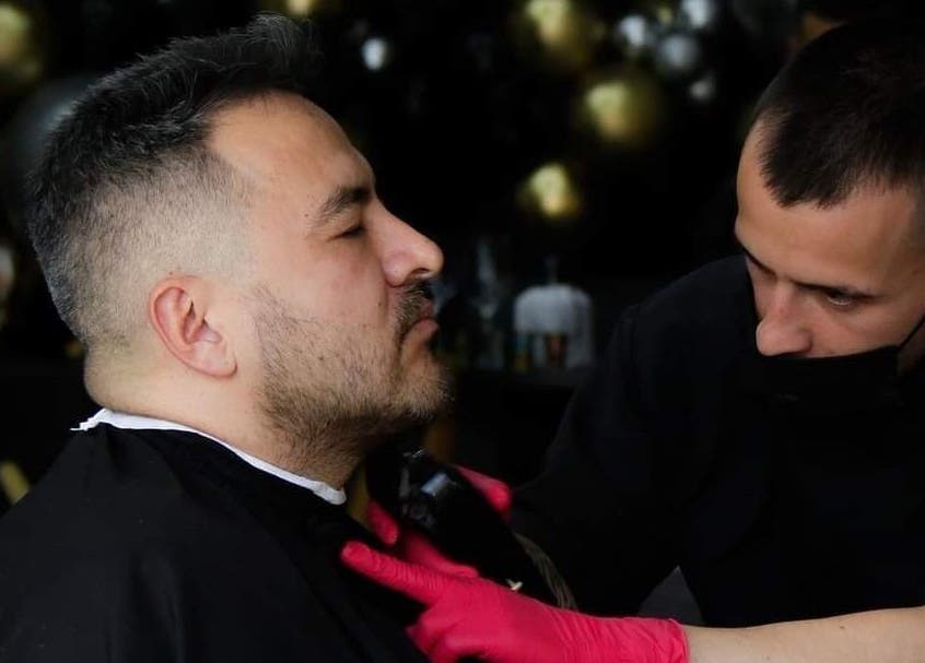 Cliente recibiendo corte de barba en Porium Barbería, Envigado, Antioquia, CO. Profesional cortando con precisión.