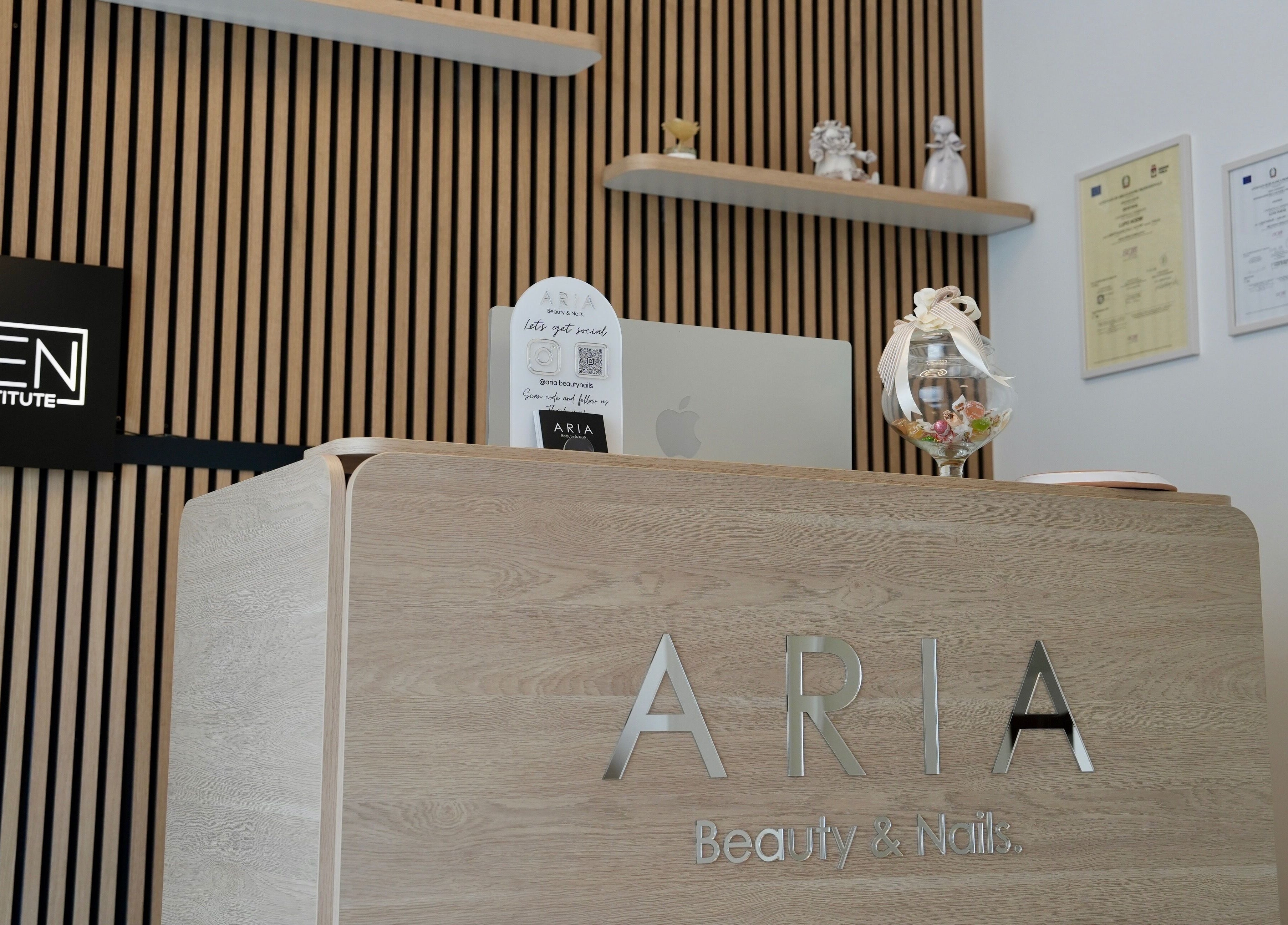 Reception di Aria Beauty & Nails a Grottaglie, Puglia, IT, con elegante banco in legno e decorazioni.