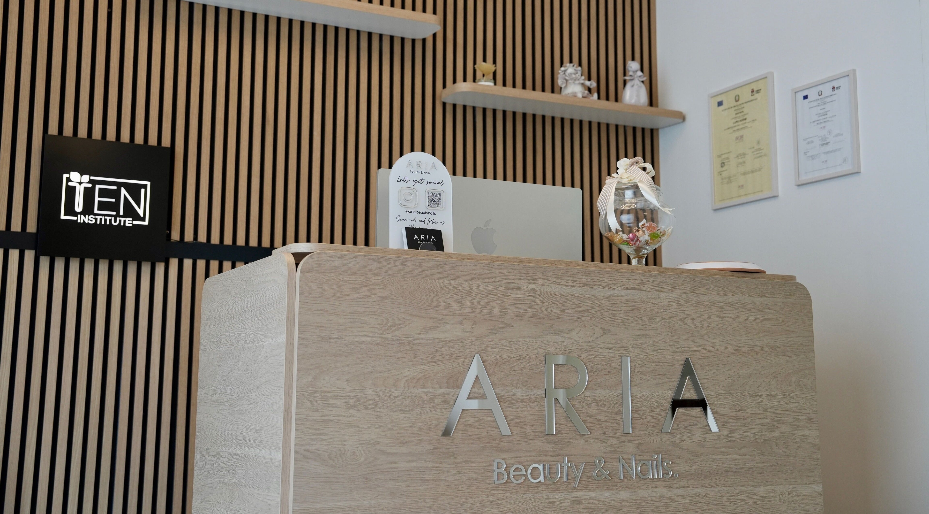 Reception di Aria Beauty & Nails a Grottaglie, Puglia, IT, con elegante banco in legno e decorazioni.