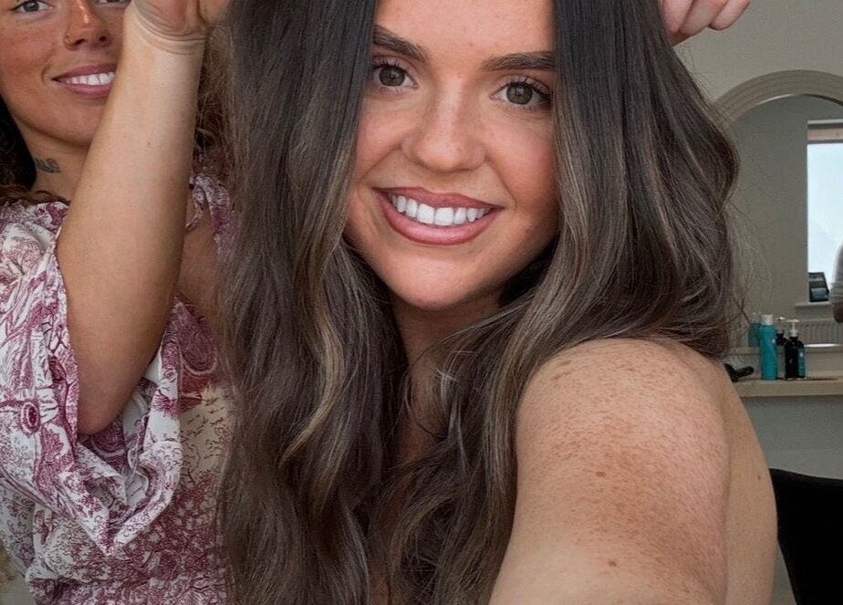 Stylist at Summer Rose Hairdressing in East Goscote, England, enhancing client's hairstyle with a vibrant touch.