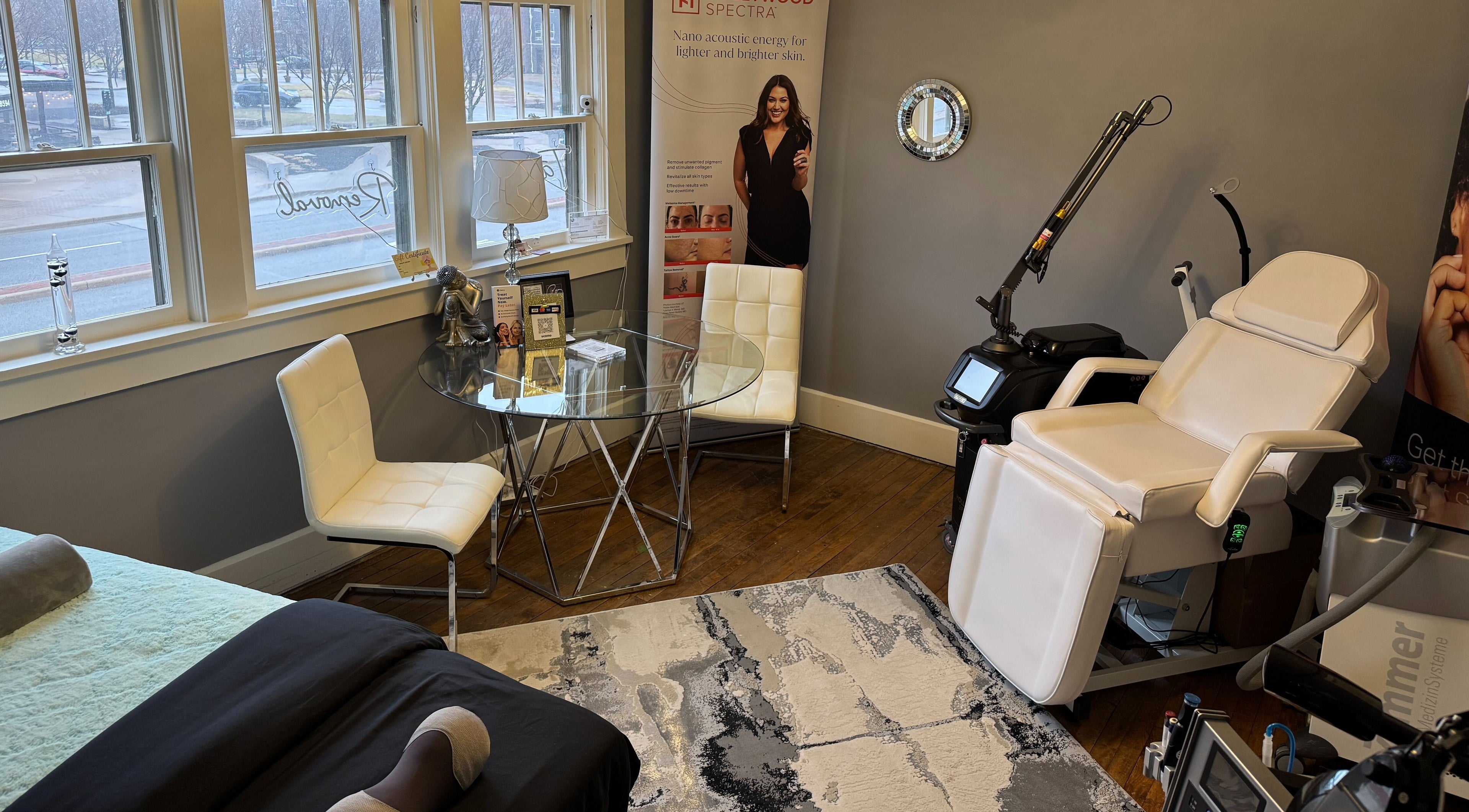 Elegant treatment room at Skin With Benefits, Fishers, Indiana, US featuring a modern chair and glass table.
