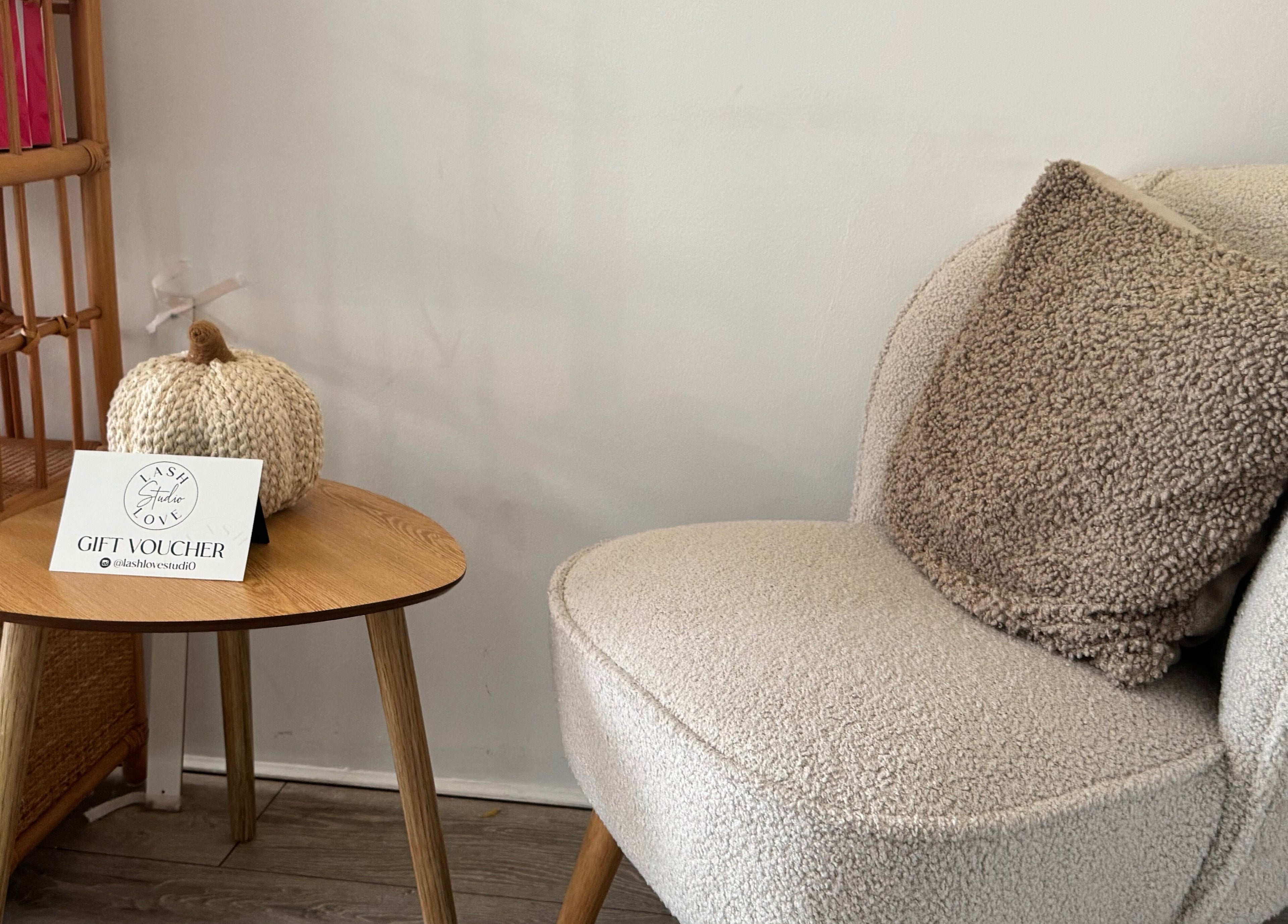 Cozy chair and table with decor at Lenka Beauty, Wirral, England, GB, showcasing a peaceful ambiance.