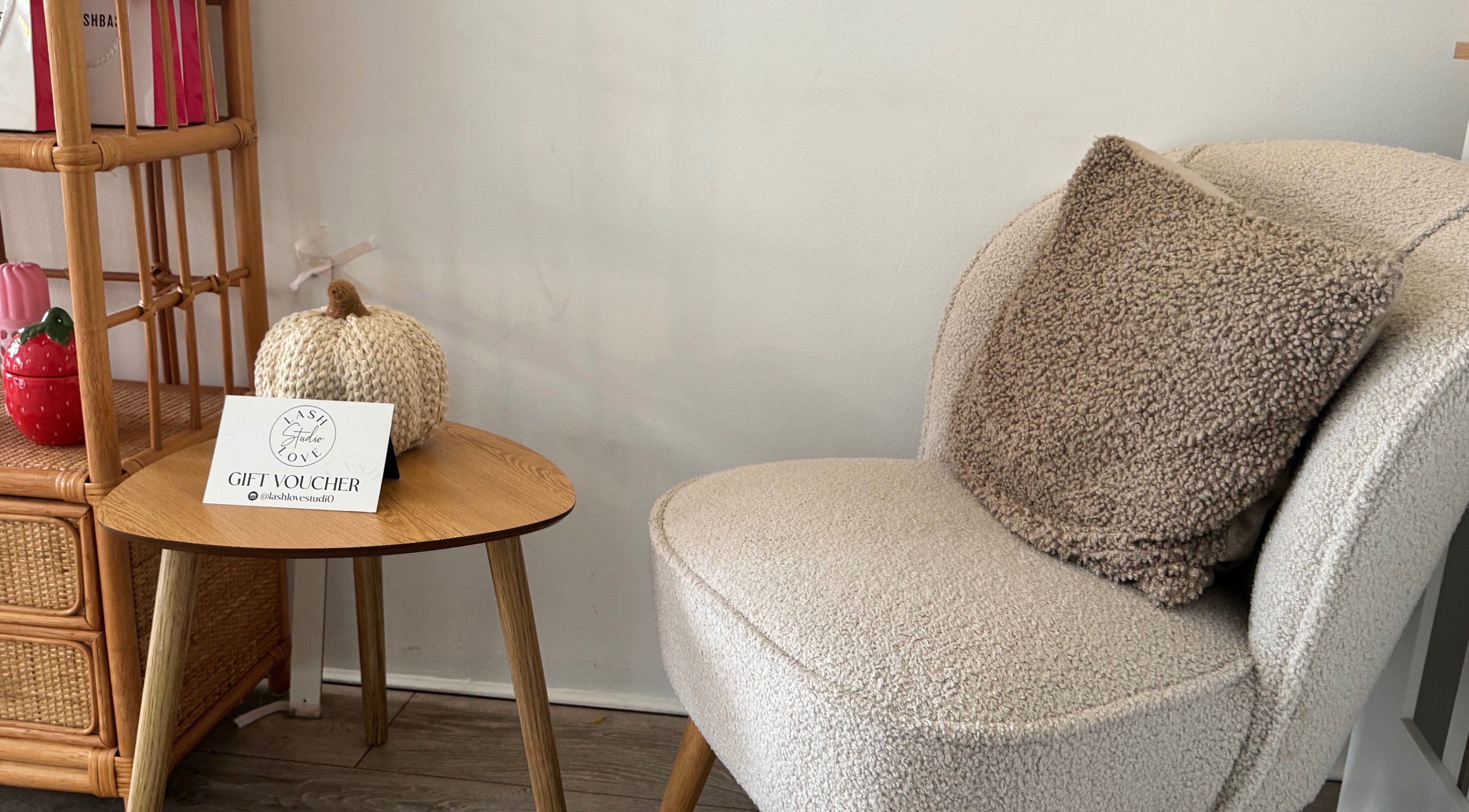 Cozy chair and table with decor at Lenka Beauty, Wirral, England, GB, showcasing a peaceful ambiance.