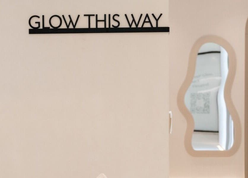 Entrance of Facette Facial Bar Jumeirah in Dubai, Dubai, AE, with 'Glow This Way' sign and modern decor.