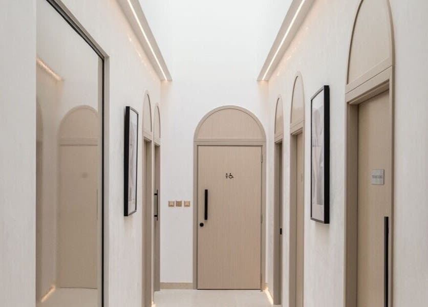 Elegant hallway at Facette Facial Bar Jumeirah, Dubai, Dubai, AE featuring modern arches and framed art.