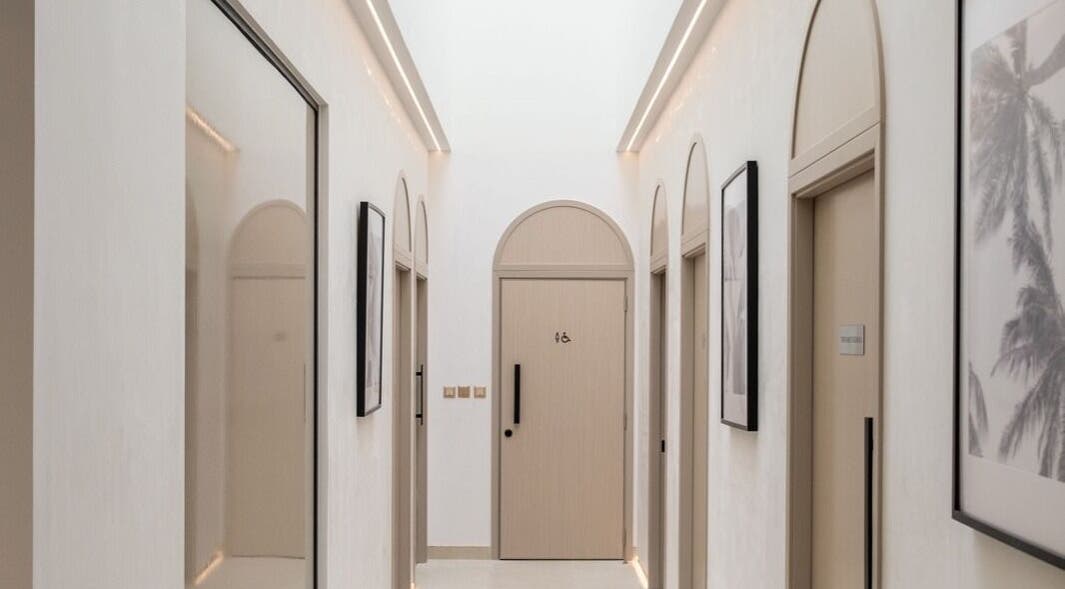 Elegant hallway at Facette Facial Bar Jumeirah, Dubai, Dubai, AE featuring modern arches and framed art.