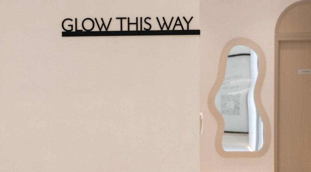 Elegant entry sign 'Glow This Way' at Facette Facial Bar Jumeirah, Dubai, Dubai, AE, inviting relaxation and beauty.