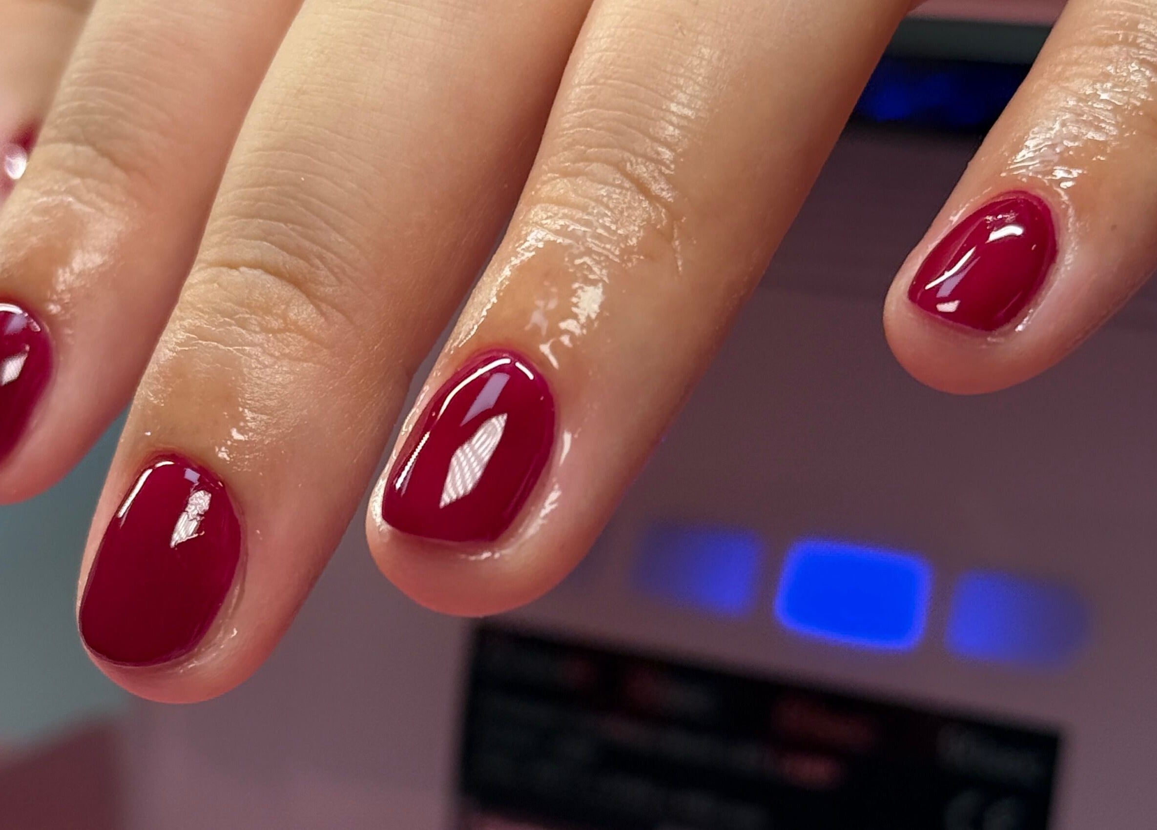 Freshly manicured nails with deep red polish at Nail Devotion, Bath, England, GB.