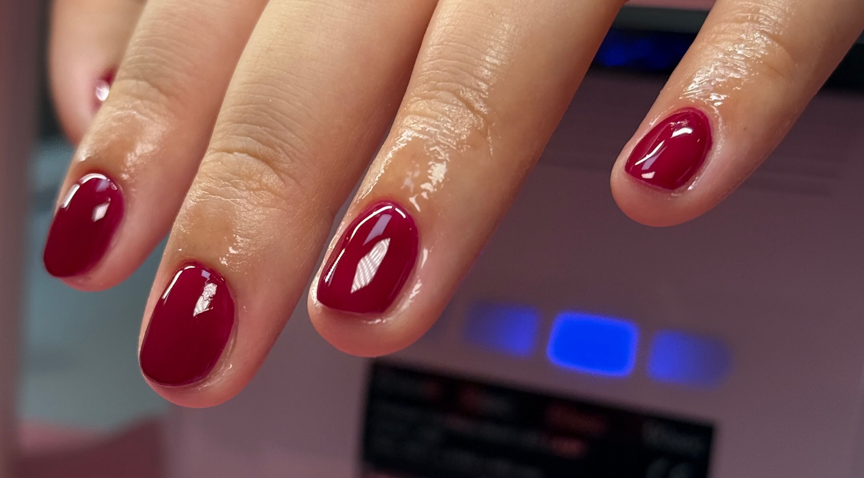 Freshly manicured nails with deep red polish at Nail Devotion, Bath, England, GB.