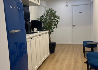 Cozinha moderna em Studio Lins Beauty, Lisboa, PT, com geladeira azul e móveis elegantes.