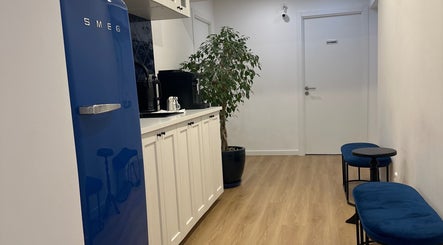 Cozinha moderna em Studio Lins Beauty, Lisboa, PT, com geladeira azul e móveis elegantes.