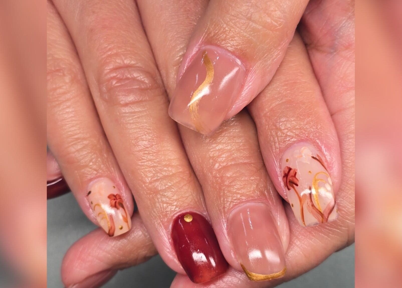 Stylish floral nail art at Sasco Nails, Henderson, Nevada, US. Featuring intricate red and gold designs.