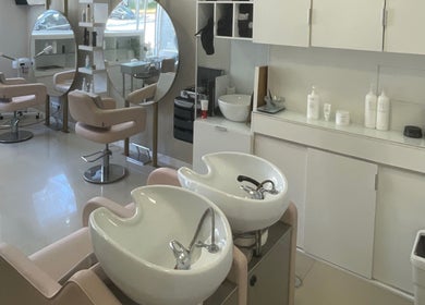 Interior sofisticado do salão Labelle Papillon em Lisboa, Lisboa, PT, com cadeiras modernas e pias elegantes.