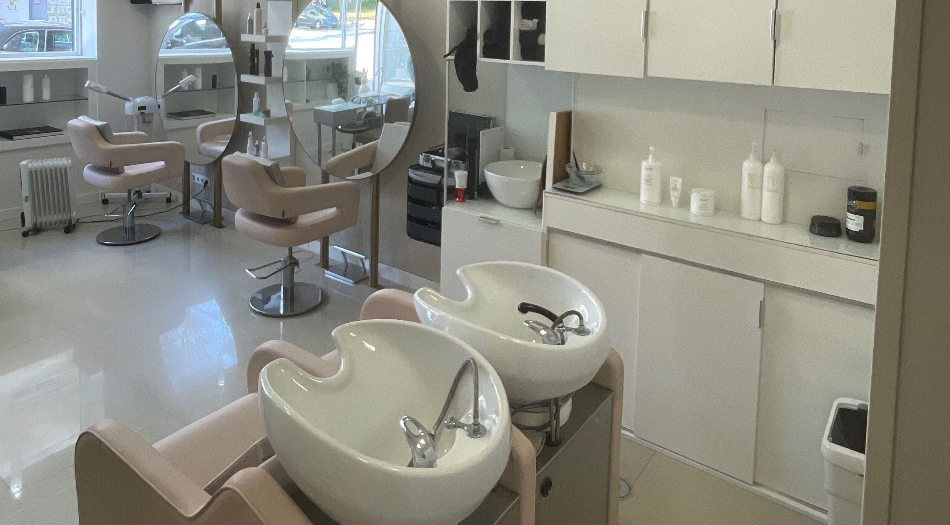 Interior sofisticado do salão Labelle Papillon em Lisboa, Lisboa, PT, com cadeiras modernas e pias elegantes.