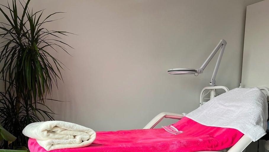 Relaxing spa bed at M’Derma London Beauty & Aesthetics, Sutton, England, GB, adorned with pink and white linens.