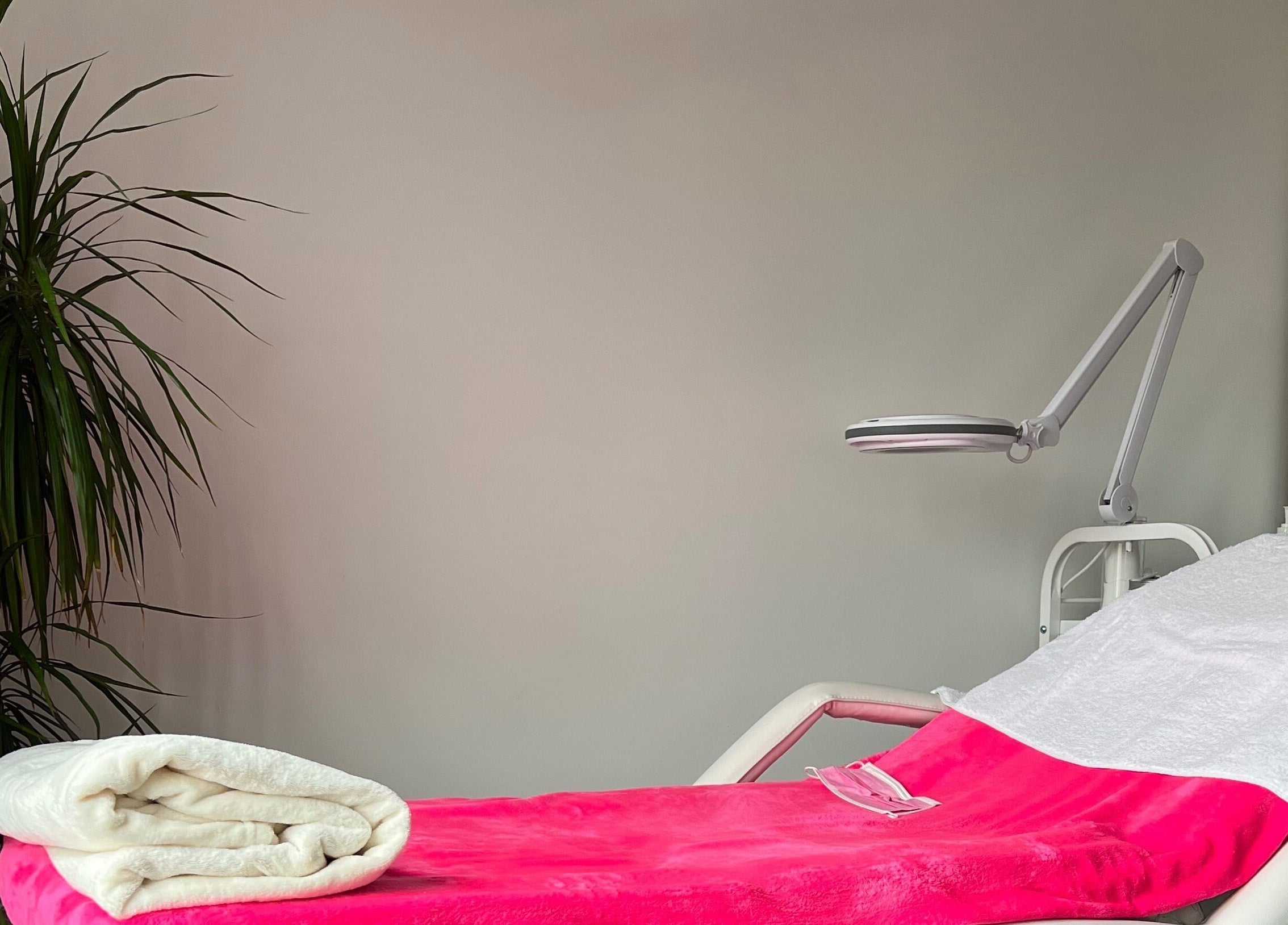 Relaxing spa bed at M’Derma London Beauty & Aesthetics, Sutton, England, GB, adorned with pink and white linens.