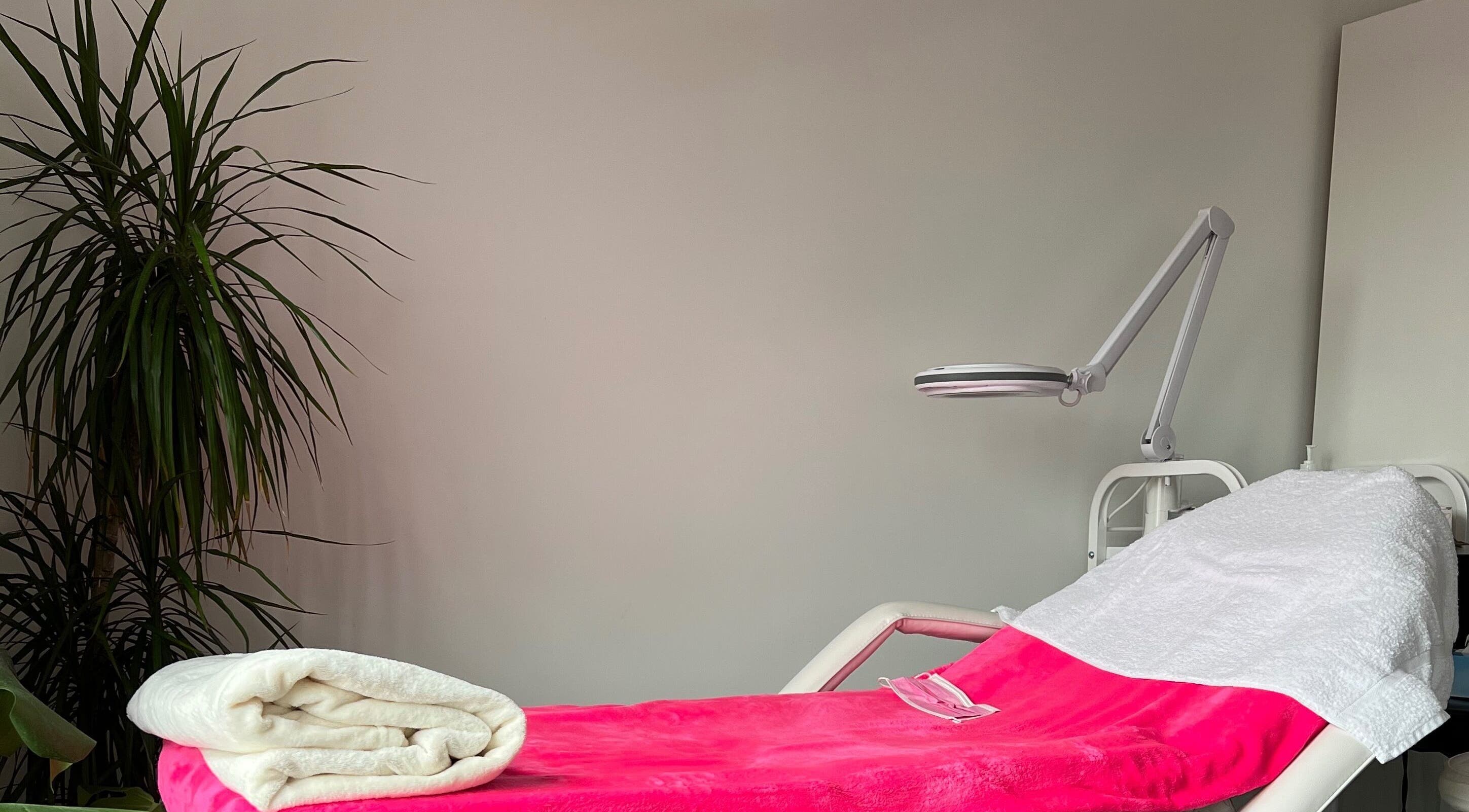 Relaxing spa bed at M’Derma London Beauty & Aesthetics, Sutton, England, GB, adorned with pink and white linens.