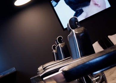Sleek black barber chairs at The Barber, London, England, GB, offering stylish grooming services.