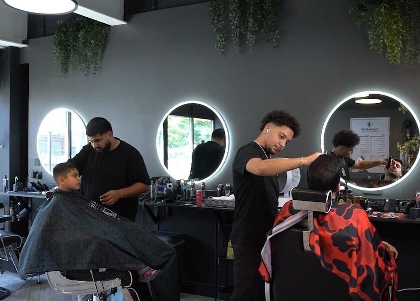 Stylish interior of The Barber in London, England, GB, featuring modern haircuts and vibrant decor.