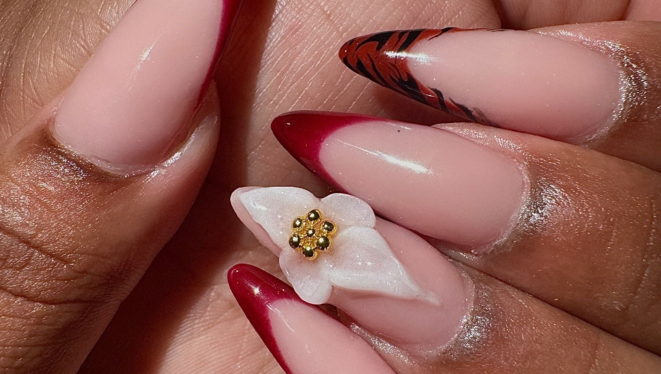 Chic red almond nails with floral design at AK Nails, Thornton, New South Wales, AU.