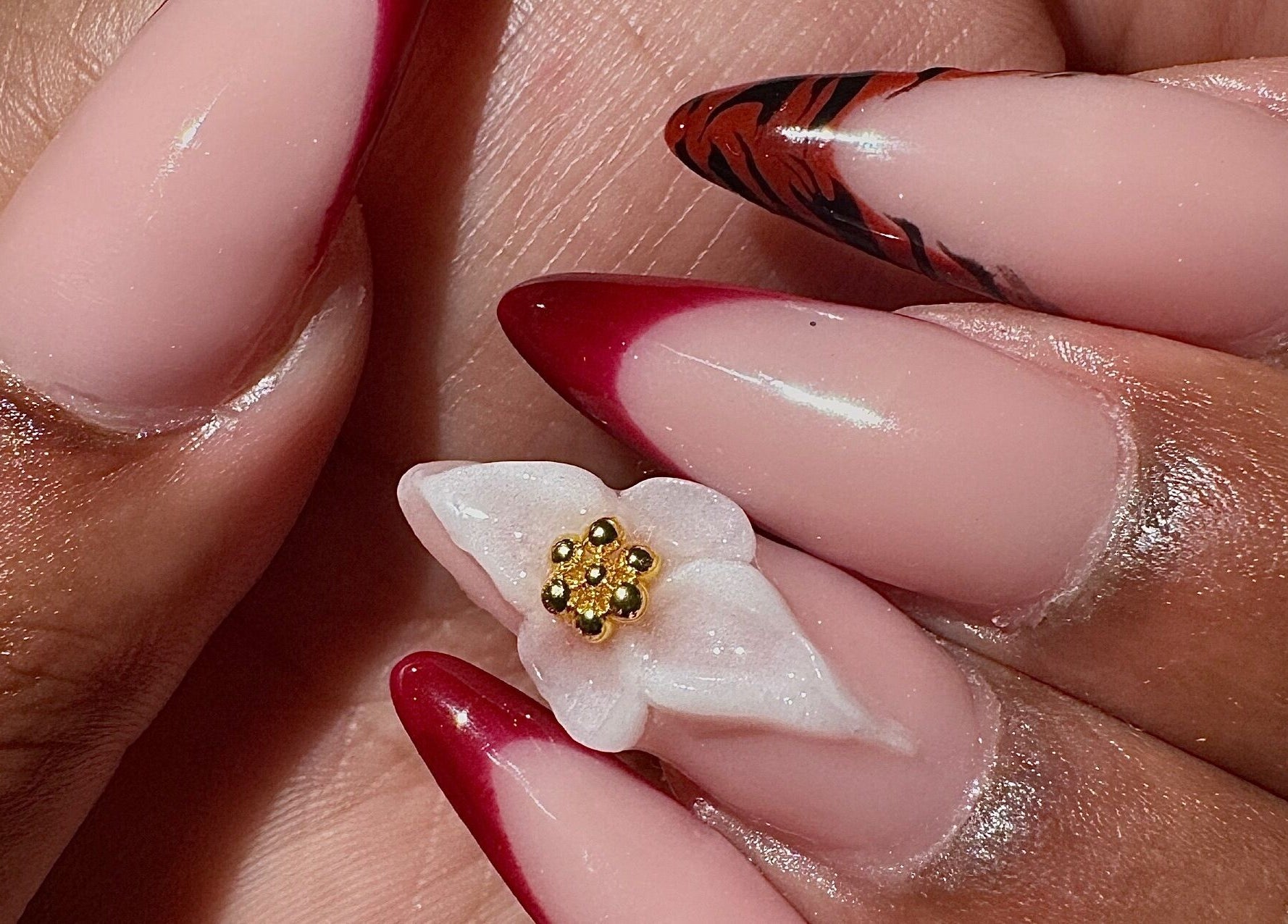 Chic red almond nails with floral design at AK Nails, Thornton, New South Wales, AU.