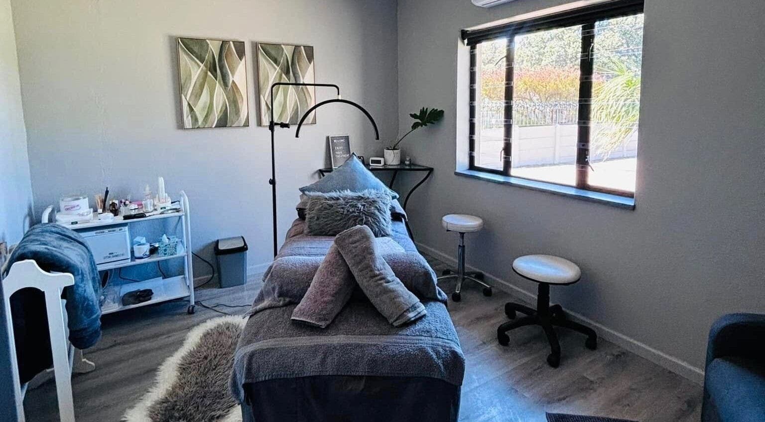 Tranquil massage room at Exhale Massage & Beauty Spa, Cape Town, Western Cape, ZA, with cozy decor and window view.