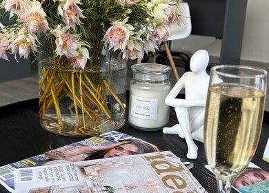 Floral display with candle and magazine at Exhale Massage & Beauty Spa, Cape Town, Western Cape, ZA.