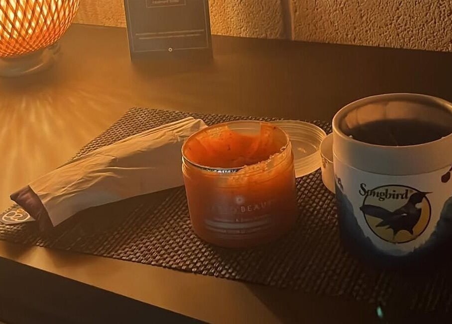 Warmly lit spa table at Beauty and Holistics by Lucie, Radstock, England, GB with candle and skincare products.