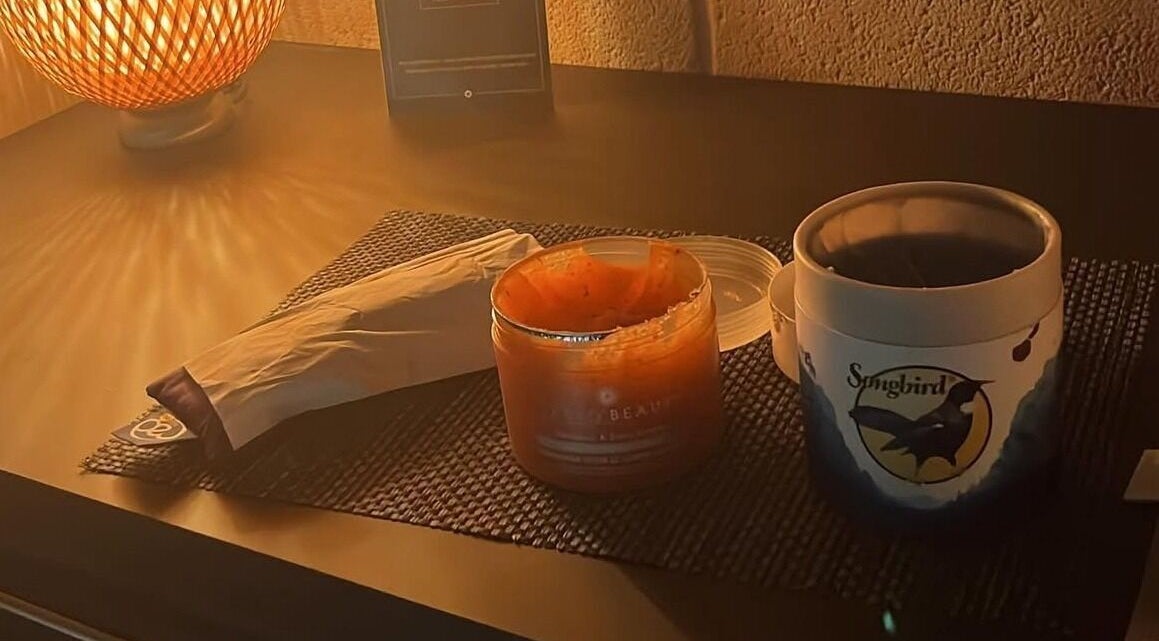 Warmly lit spa table at Beauty and Holistics by Lucie, Radstock, England, GB with candle and skincare products.