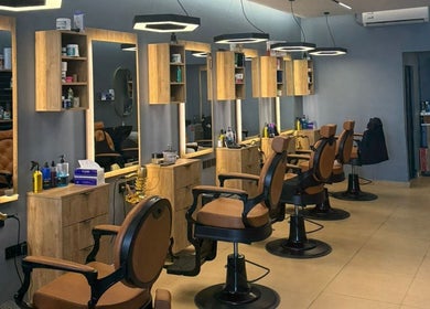Modern salon interior at Elite Style, Riyadh, SA with stylish chairs and lighting for an upscale experience.