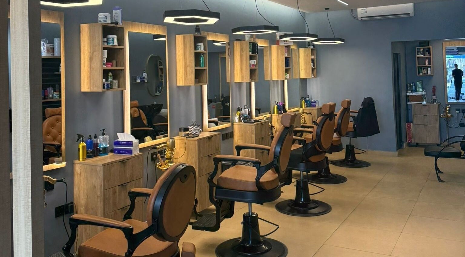 Modern salon interior at Elite Style, Riyadh, SA with stylish chairs and lighting for an upscale experience.