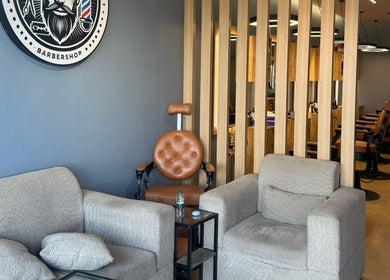 Modern waiting area at Elite Style, Riyadh, SA, featuring plush seating and barber decor.