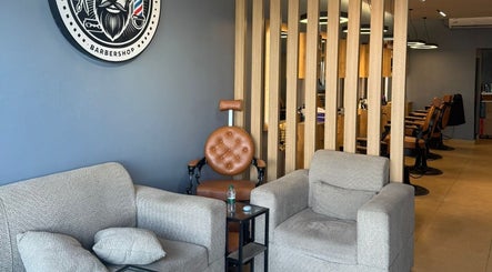 Modern waiting area at Elite Style, Riyadh, SA, featuring plush seating and barber decor.