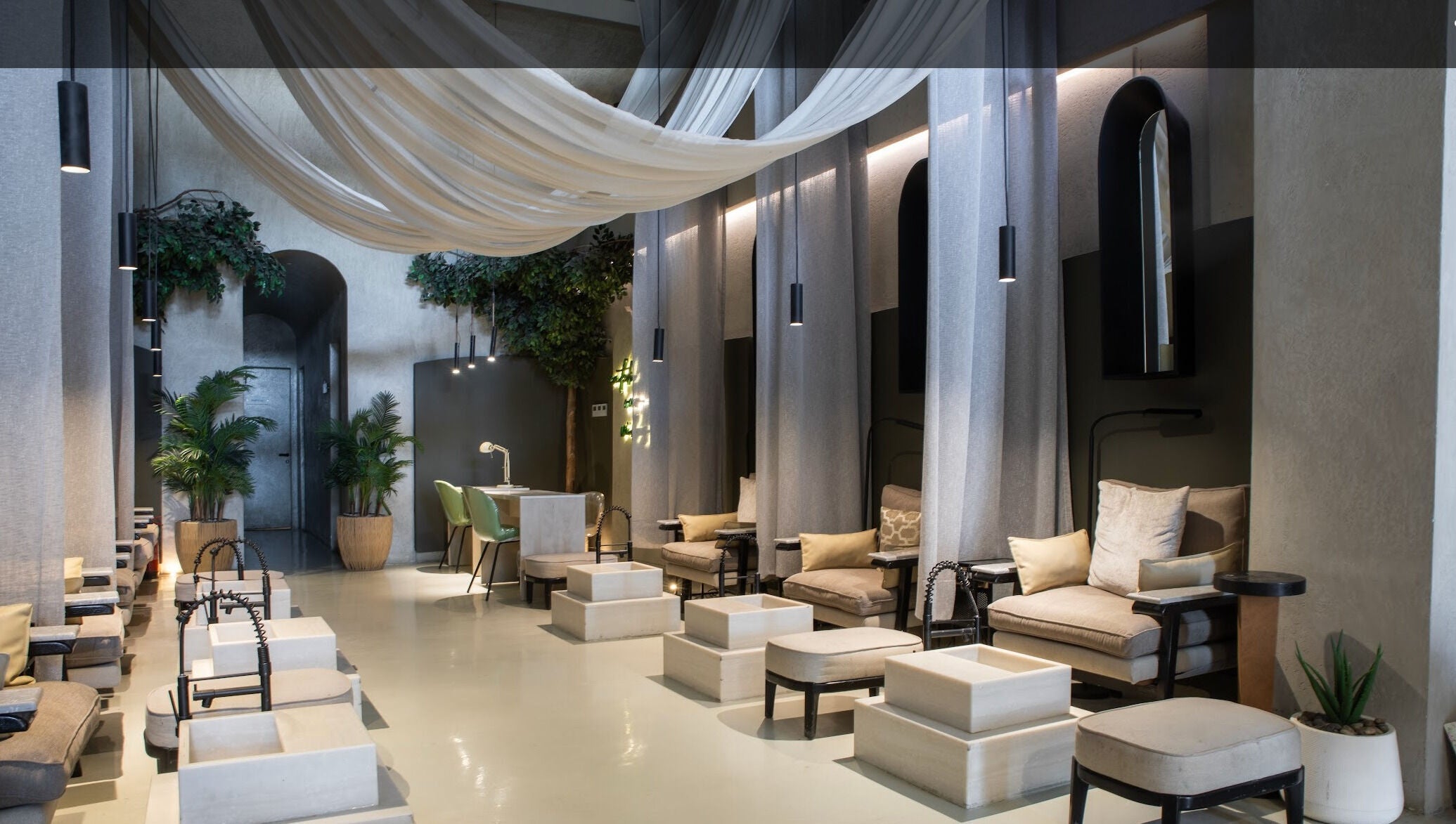 Elegant interior of Nails Aholic - Ar Rahmaniyyah in Riyadh, SA, with plush seating and ambient lighting.