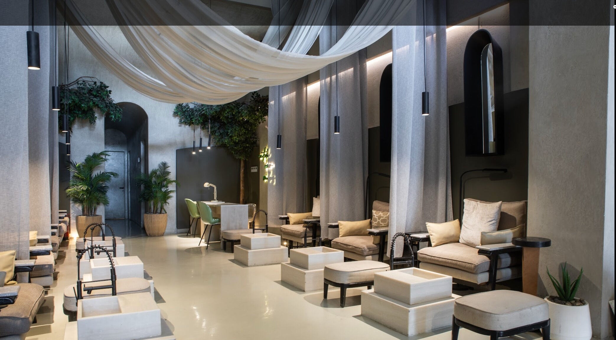 Elegant interior of Nails Aholic - Ar Rahmaniyyah in Riyadh, SA, with plush seating and ambient lighting.