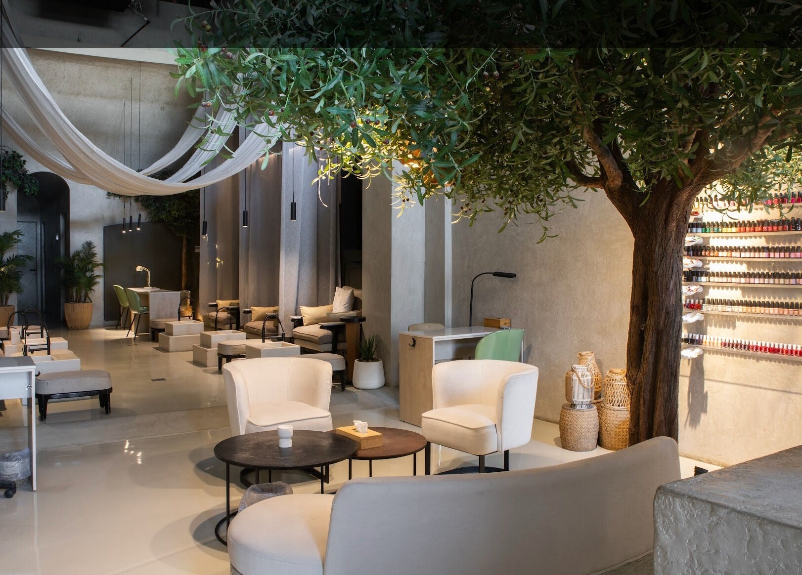 Elegant interior of Nails Aholic - Ar Rahmaniyyah in Riyadh, showcasing chic seating and a vast nail polish display.