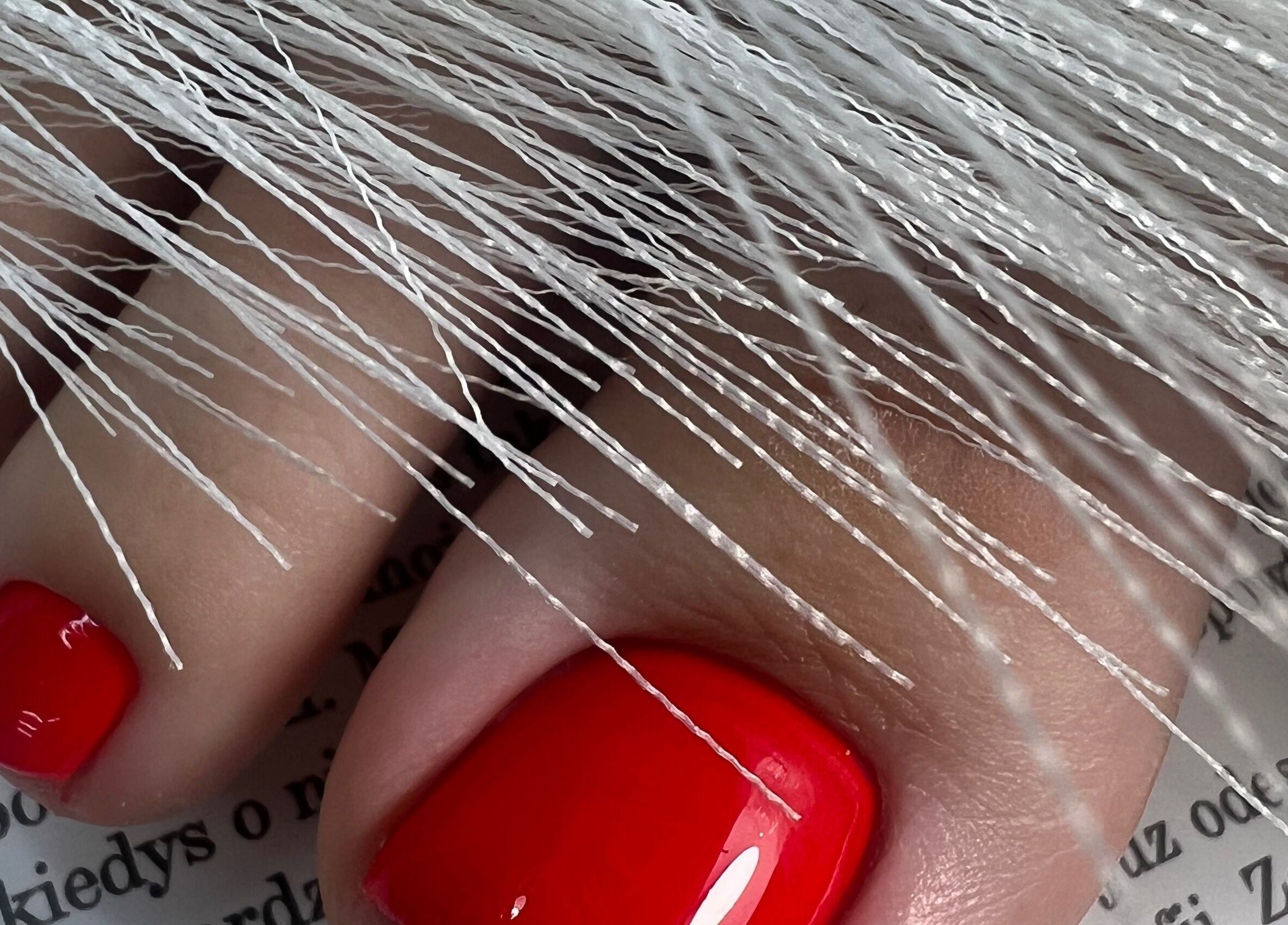Close-up of vibrant red pedicure with artistic details at Dangina Studio, Aurora, Illinois, US.